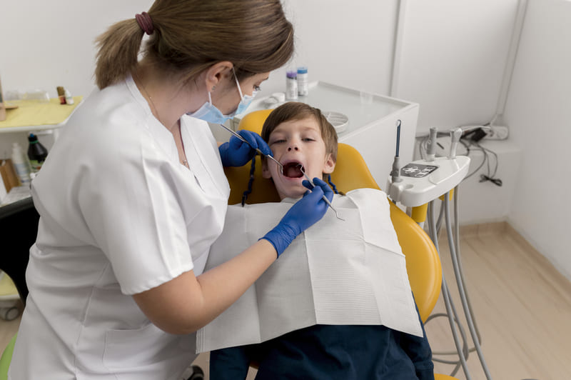 Criança no dentista fazendo uma limpeza.